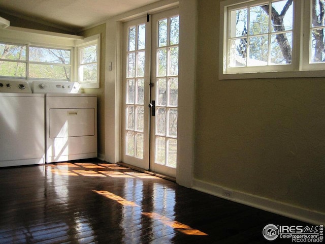 laundry room featuring washer and dryer, french doors, hardwood / wood-style flooring, and a healthy amount of sunlight