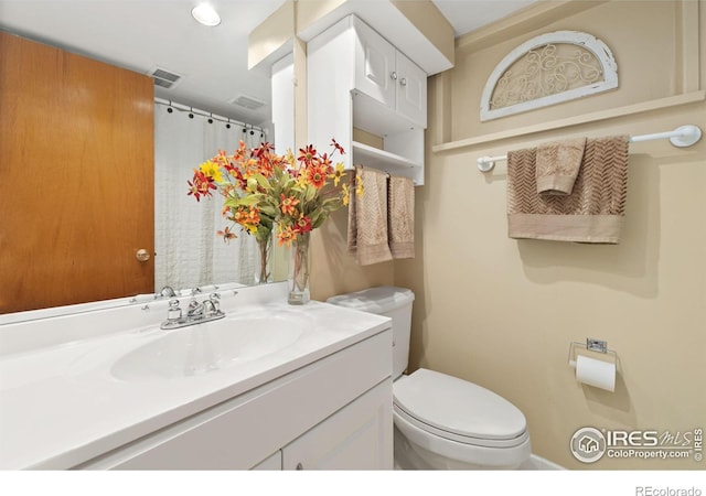 bathroom with toilet, visible vents, a shower with shower curtain, and vanity