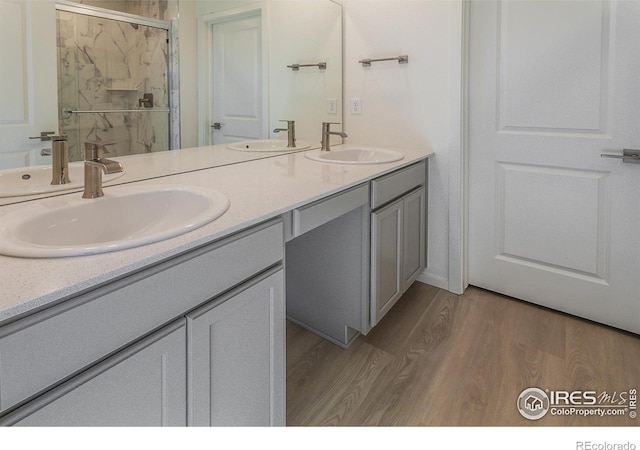5086 Mckinnon Ct, Timnath, CO 80547 - bathroom featuring wood finished floors, a marble finish shower, and double vanity