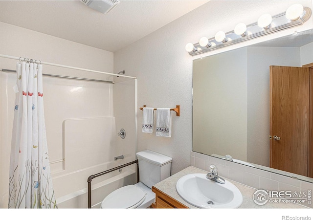 full bathroom featuring shower / bath combo, toilet, a textured ceiling, and vanity