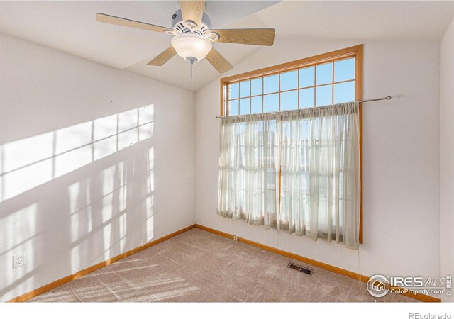 carpeted empty room featuring ceiling fan and vaulted ceiling