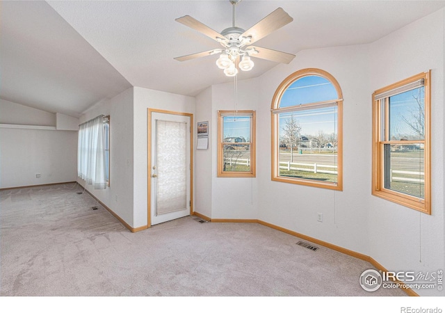 carpeted entrance foyer with ceiling fan and lofted ceiling