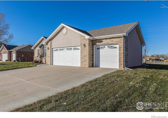 view of property exterior with a garage and a lawn