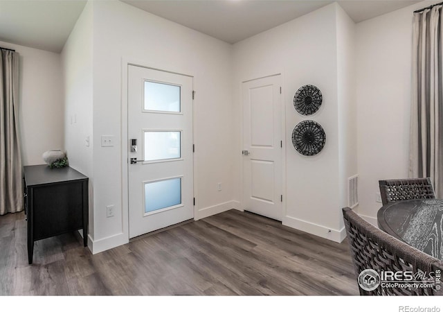 entryway with dark wood-type flooring, visible vents, and baseboards