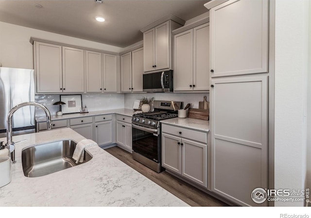 kitchen featuring a sink, appliances with stainless steel finishes, recessed lighting, dark wood-type flooring, and decorative backsplash