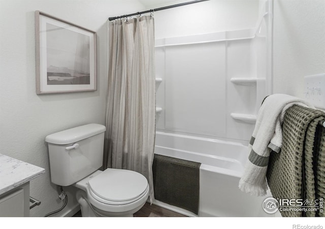 bathroom featuring vanity, toilet, visible vents, shower / bath combo with shower curtain, and wood finished floors