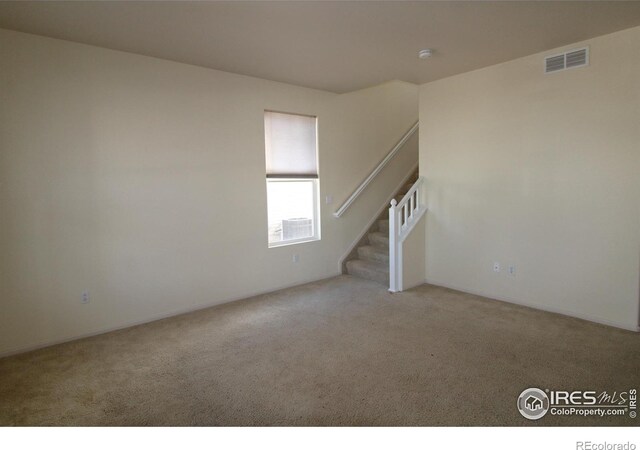 unfurnished living room with light colored carpet