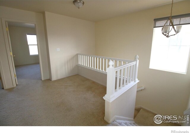 interior space featuring light colored carpet and a notable chandelier