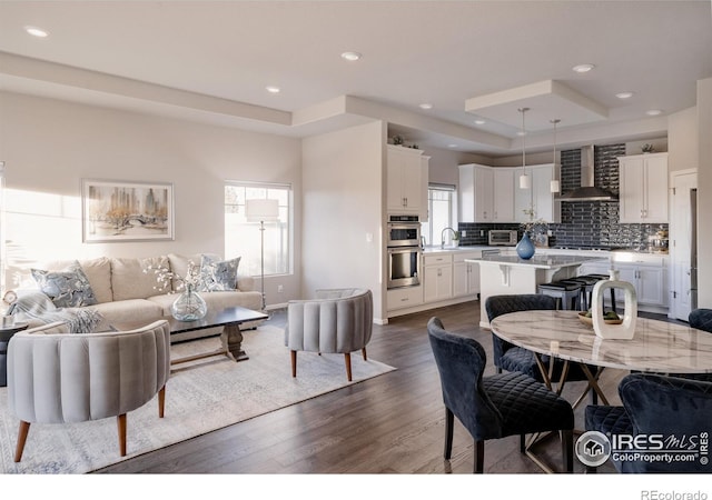 living area with baseboards, dark wood-style flooring, and recessed lighting