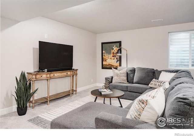 living area featuring carpet floors, baseboards, and visible vents