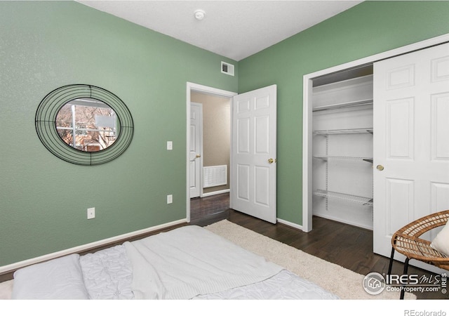 bedroom featuring dark wood-type flooring and a closet