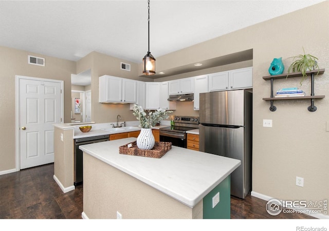 kitchen with hanging light fixtures, white cabinetry, appliances with stainless steel finishes, and a kitchen island