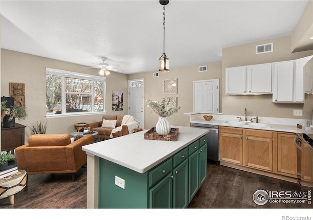 kitchen featuring appliances with stainless steel finishes, decorative light fixtures, white cabinetry, sink, and a center island