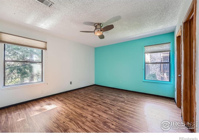 spare room with hardwood / wood-style floors, a textured ceiling, and ceiling fan