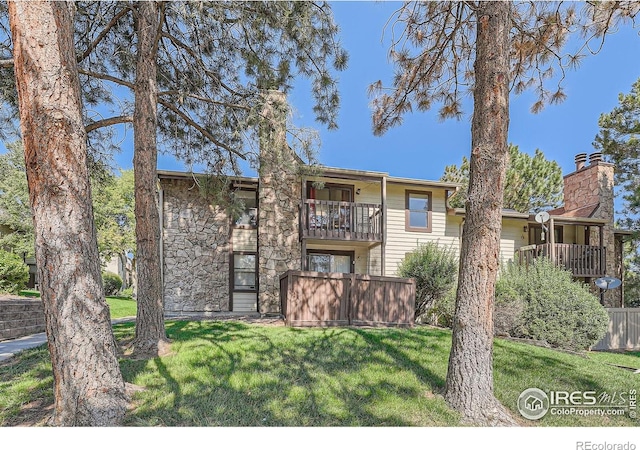 back of property with a balcony and a yard