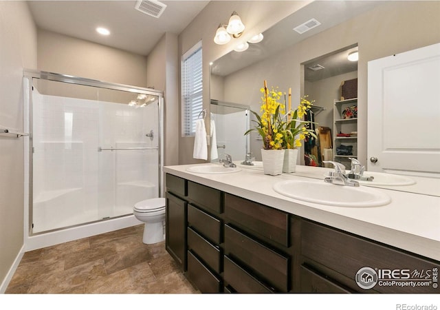 bathroom with a shower with door, vanity, and toilet