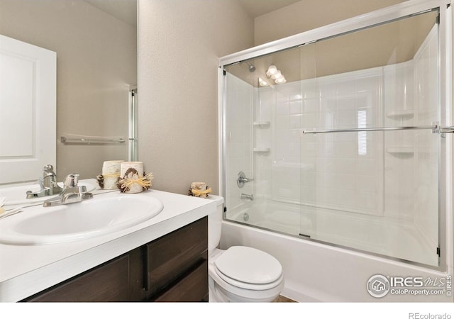 full bathroom featuring vanity, shower / bath combination with glass door, and toilet