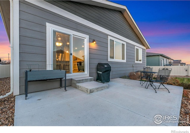 patio terrace at dusk featuring area for grilling