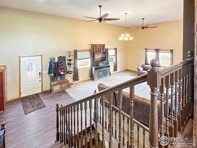 living room with dark hardwood / wood-style flooring and ceiling fan with notable chandelier