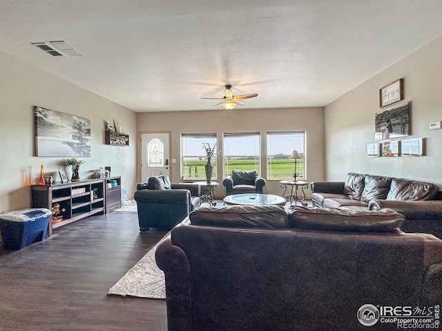 living room featuring dark wood-type flooring and ceiling fan