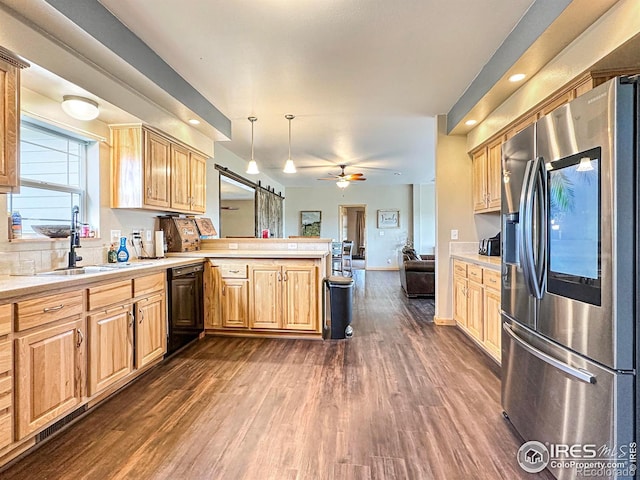 kitchen featuring sink, stainless steel fridge, dishwasher, kitchen peninsula, and pendant lighting