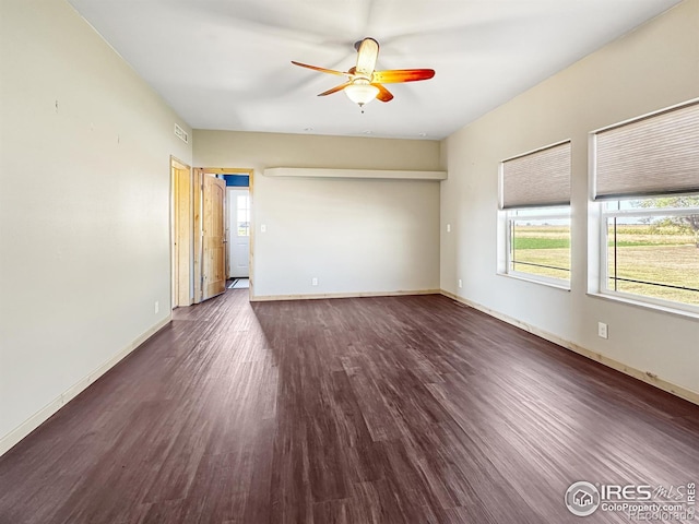 spare room featuring dark wood-type flooring and ceiling fan