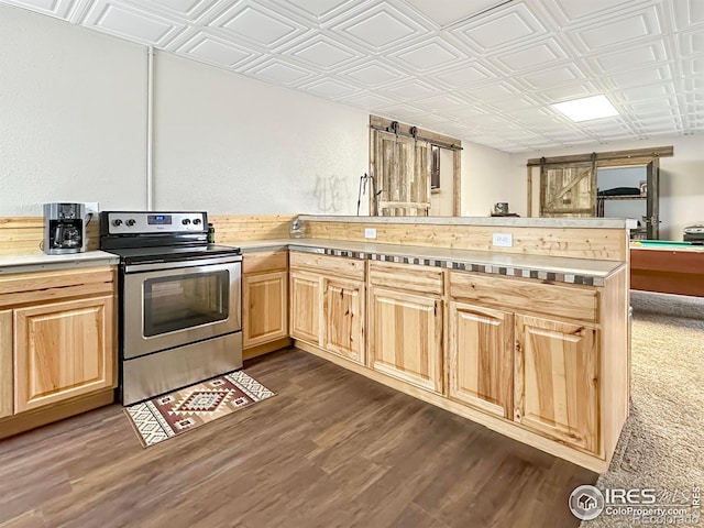 kitchen featuring dark hardwood / wood-style floors, kitchen peninsula, a barn door, light brown cabinets, and stainless steel electric range