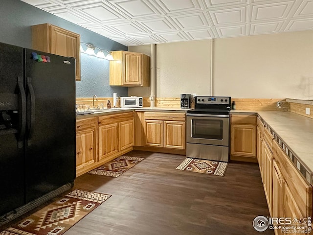 kitchen with dark wood-type flooring, light brown cabinetry, sink, black fridge, and stainless steel range with electric stovetop