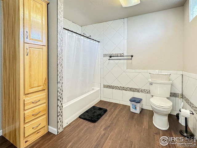 bathroom featuring wood-type flooring, toilet, tile walls, and shower / bath combo with shower curtain