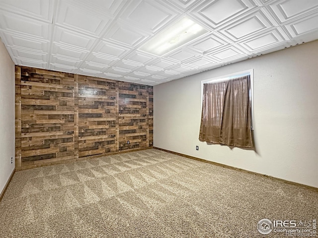 spare room with carpet floors and wooden walls