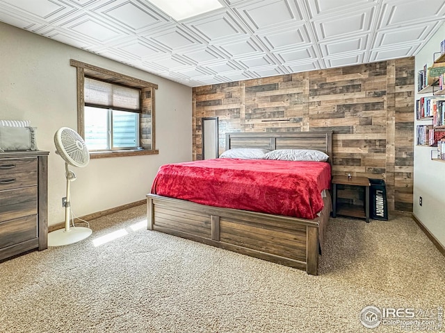 bedroom with carpet flooring and wood walls