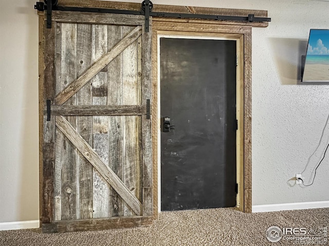 interior space with a barn door and carpet