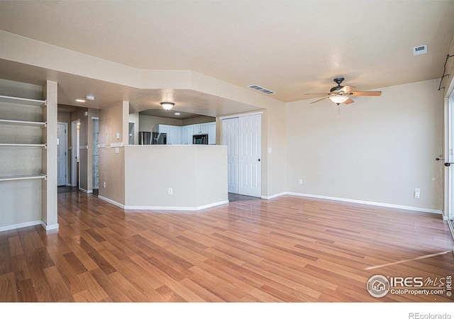 unfurnished living room with a textured ceiling, hardwood / wood-style flooring, and ceiling fan