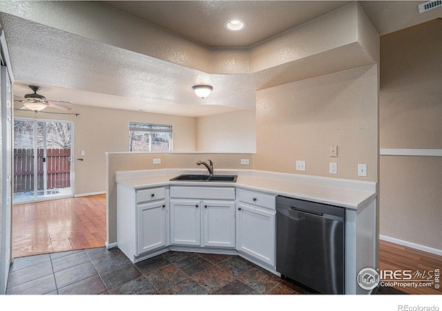 kitchen featuring sink, kitchen peninsula, stainless steel dishwasher, dark hardwood / wood-style floors, and white cabinetry