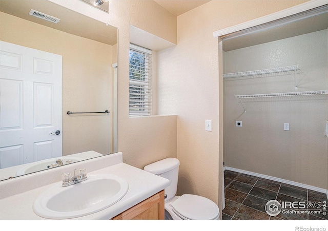 bathroom featuring tile patterned floors, vanity, and toilet