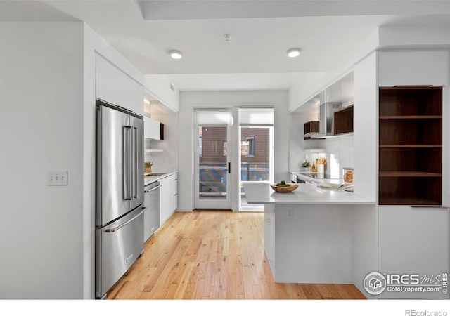 kitchen featuring light hardwood / wood-style floors, white cabinetry, stainless steel appliances, and tasteful backsplash