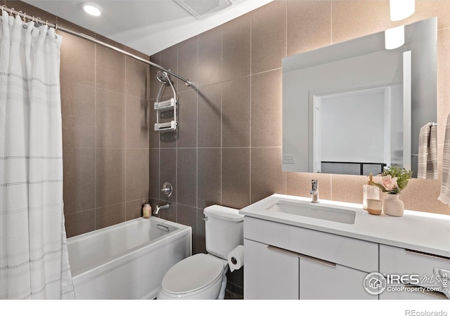 full bathroom featuring shower / bath combination with curtain, toilet, tile walls, and vanity