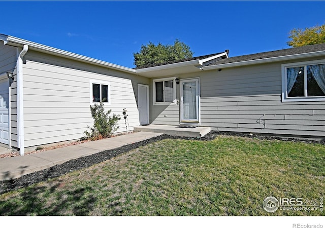 property entrance with a garage and a yard