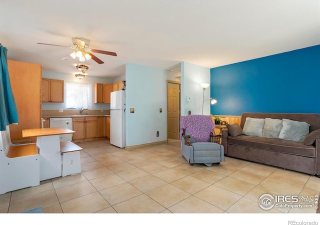 living room featuring ceiling fan, light tile patterned floors, and sink