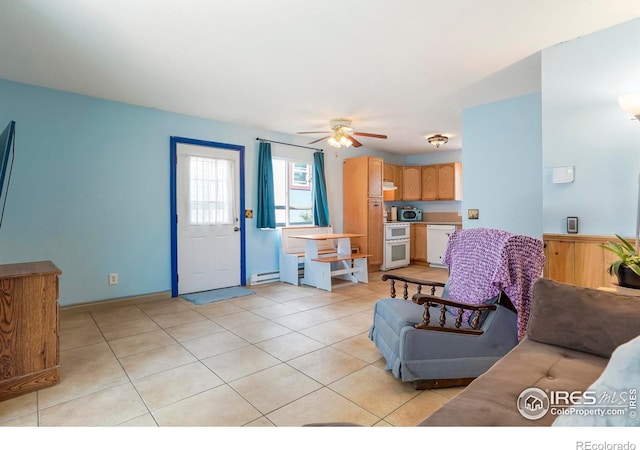 living room featuring ceiling fan, light tile patterned floors, and baseboard heating