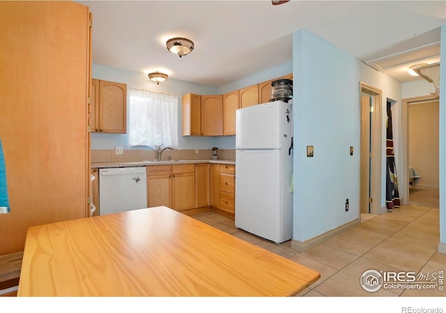 kitchen with light brown cabinetry, white appliances, and light tile patterned floors