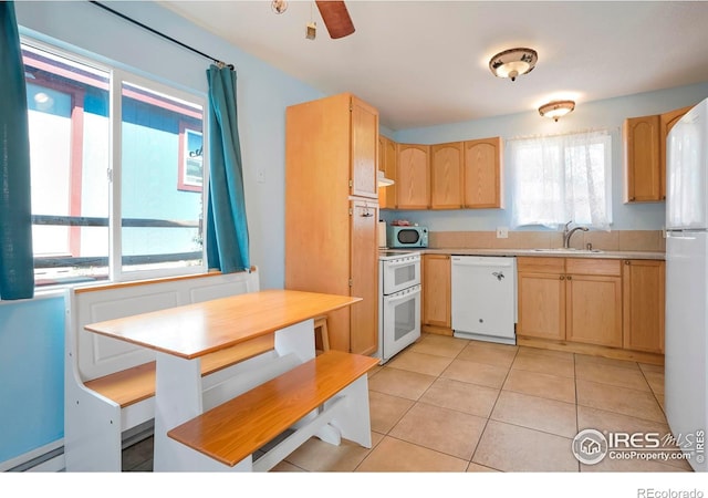 kitchen featuring light brown cabinetry, white appliances, and sink