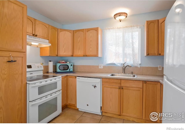 kitchen with light brown cabinetry, sink, light tile patterned floors, and white appliances