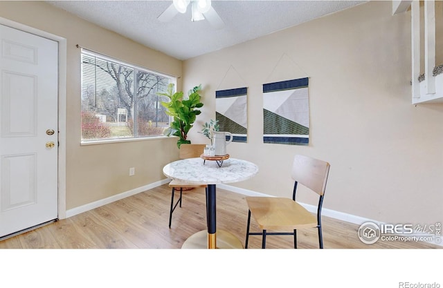 dining area featuring a textured ceiling, light hardwood / wood-style floors, and ceiling fan