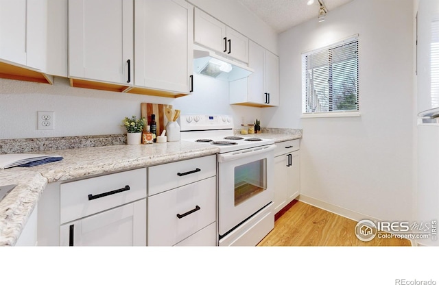 kitchen featuring white cabinets, electric range, a textured ceiling, light hardwood / wood-style floors, and light stone counters