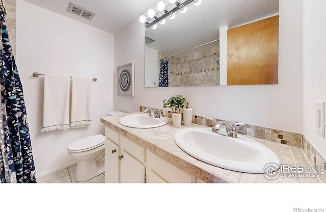 bathroom featuring tile patterned flooring, vanity, and toilet