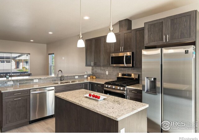 kitchen with a kitchen island, hanging light fixtures, stainless steel appliances, dark brown cabinets, and a sink