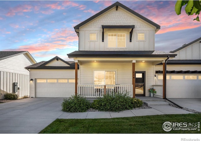 view of front facade with a garage, driveway, a porch, and board and batten siding