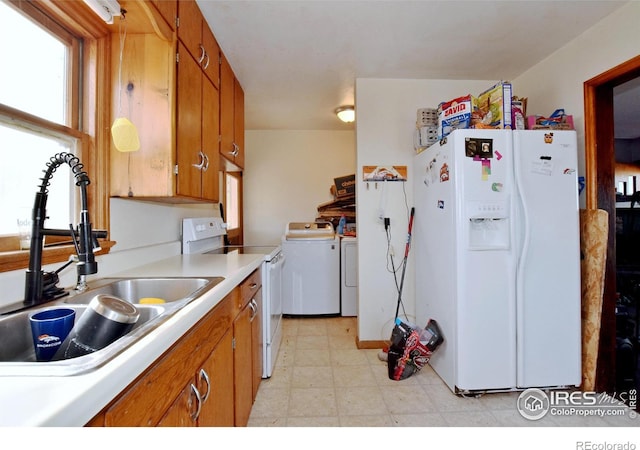 kitchen featuring sink, washer and dryer, and white appliances