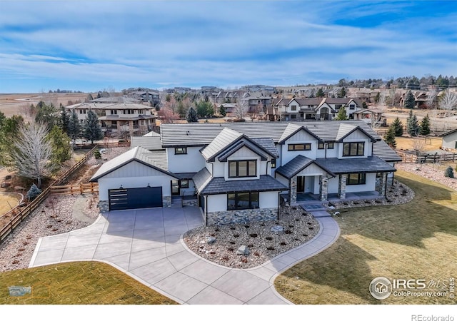 view of front of home featuring stone siding, a residential view, a front lawn, and stucco siding